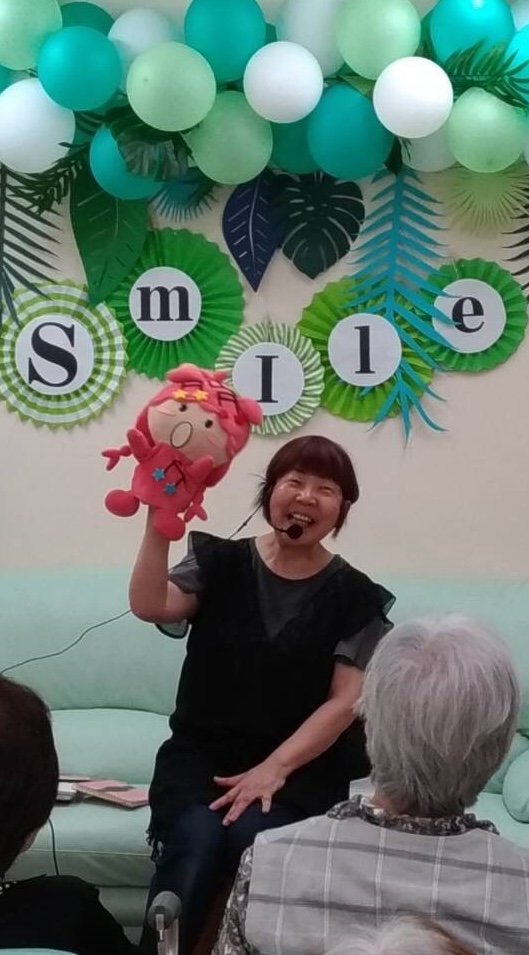 SMILEイベント慰問演奏でぽんちゃんを掲げて歌うまえぽん